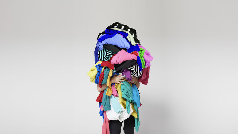 Someone holding a pile of clothes full of polyester