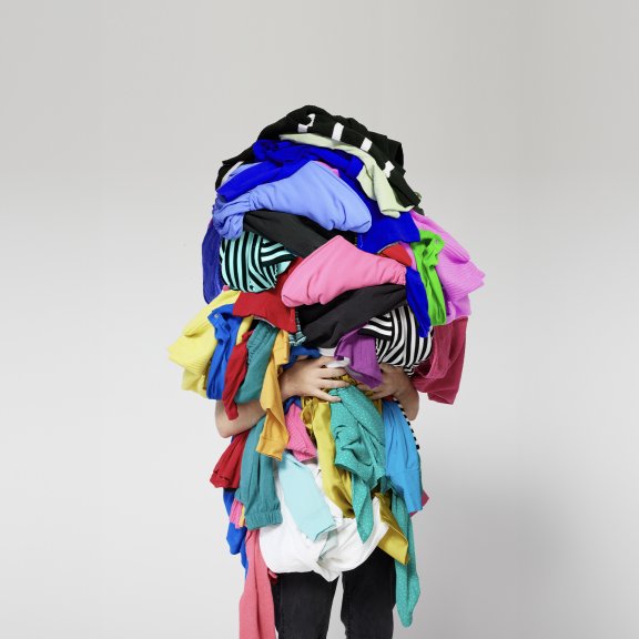 Someone holding a pile of clothes full of polyester